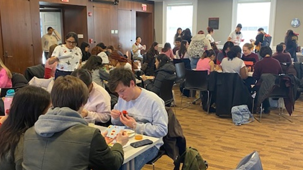 Students sitting at tables putting together Lego flowers